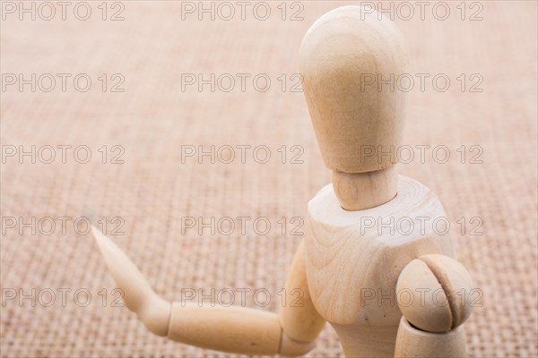 Wooden dolls of a man posing on canvas