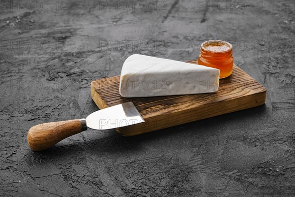 Piece of soft brie or camembert cheese on cutting board