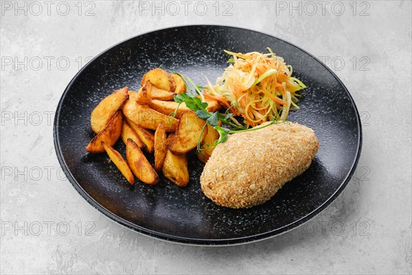 Cutlet stuffed with cheese served with fried potato wedges and sauerkraut