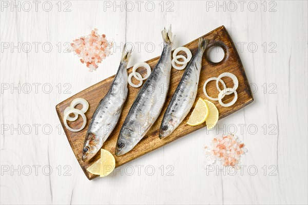 Top view of salted iwashi herring fish marinated in spice on wooden cutting board