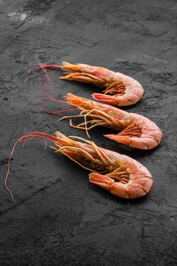 Three fresh raw prawns on wooden background