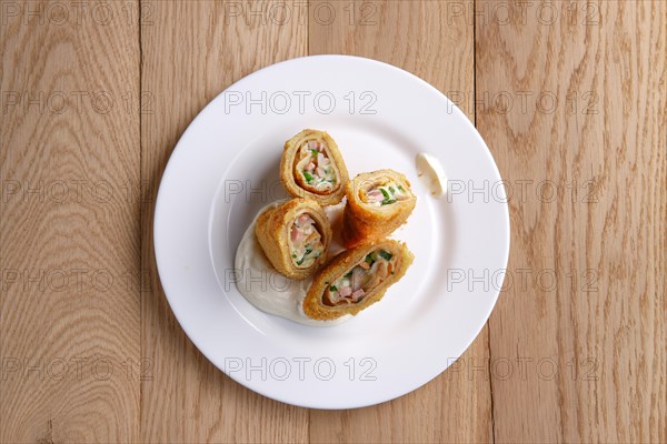 Top view of deep-fried pancakes stuffed with ham and covered with melted cheese