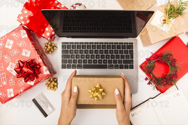 Woman holding gift box while shopping online table with christmas decoration. Resolution and high quality beautiful photo