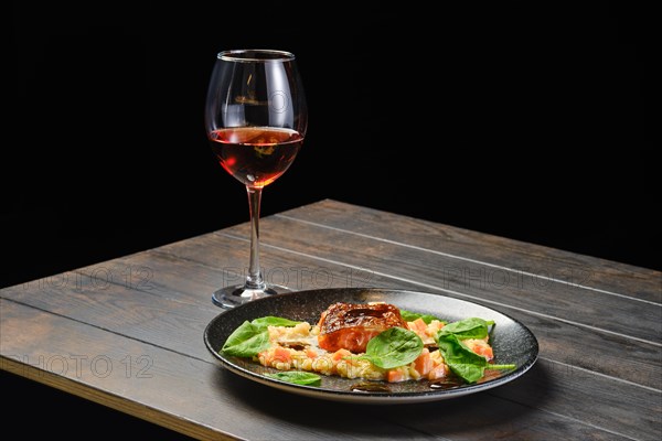 Roasted salmon fillet with bulgur with glass of rose wine on a table