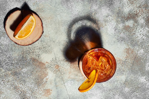 Top view of old fashioned cocktail with strong directional light forming harsh shadow