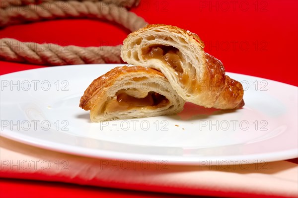 Fresh baked croissant on plate divided on pieces