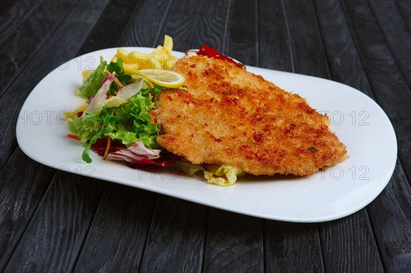 Fried chopped pork cutlet with potato balls and creamy sauce with mushroom and onion