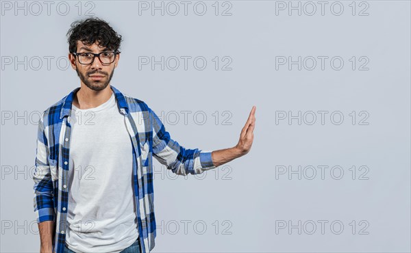 Displeased young man rejecting with rejection gesture