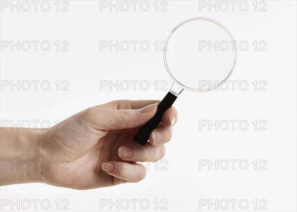 Hand holding magnifying glass