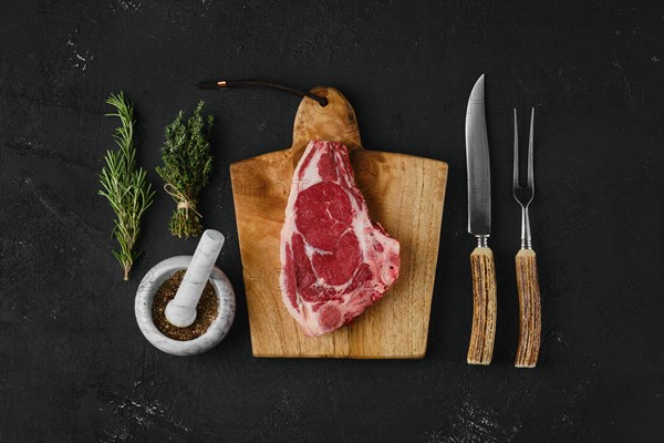 Top view of raw strip steak bone in on dark background