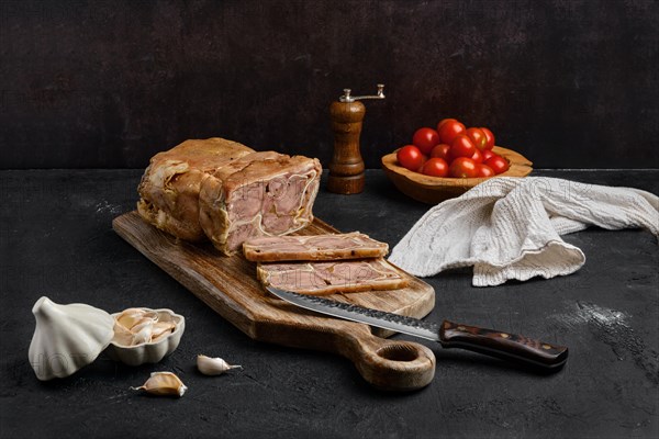 Boiled beef tongue roll on wooden cutting board