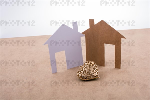Heart shaped icon and paper houses on a brown background