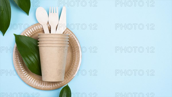Disposable plates with cups cutlery blue copy space background