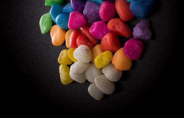 Pile of little colorful pebbles on black background