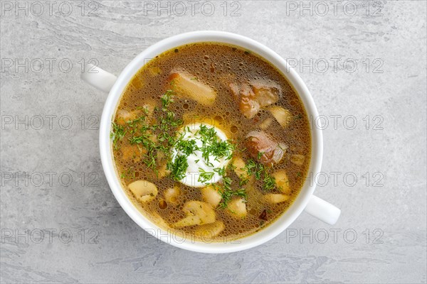 Top view of mushrooms and potato soup with sour cream