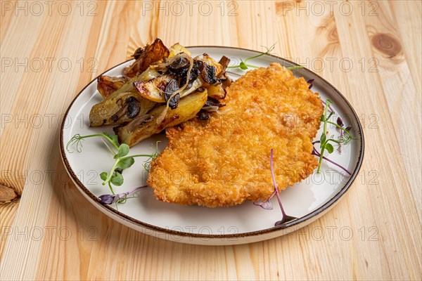 Tasty schnitzel in breading with fried potato