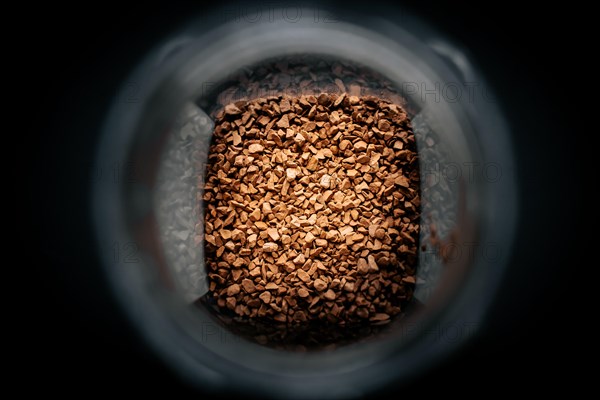 Photo of a jar with instant coffee in a dark background