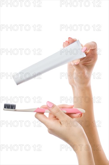 Female hands with toothbrush and paste isolated on white background