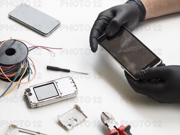 Man holding phone with broken display