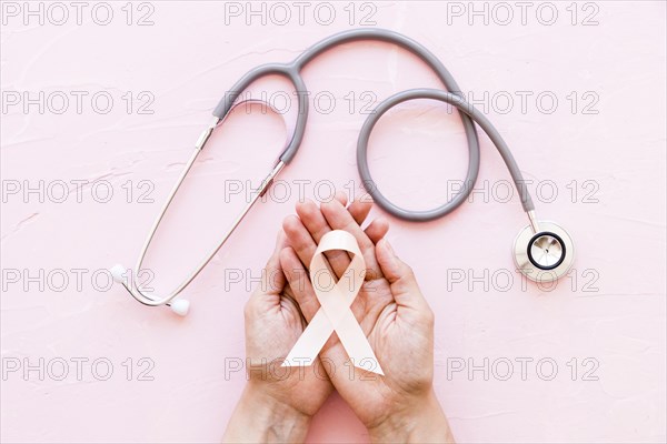 White awareness ribbon two hands with stethoscope pink background 1. Resolution and high quality beautiful photo
