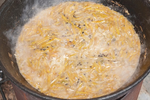 The making of pilaf in cauldron