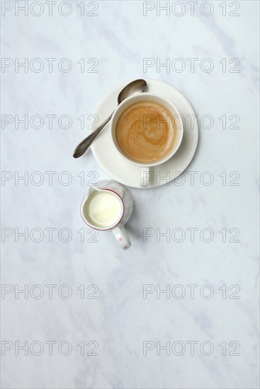 Cup with coffee and pot of milk