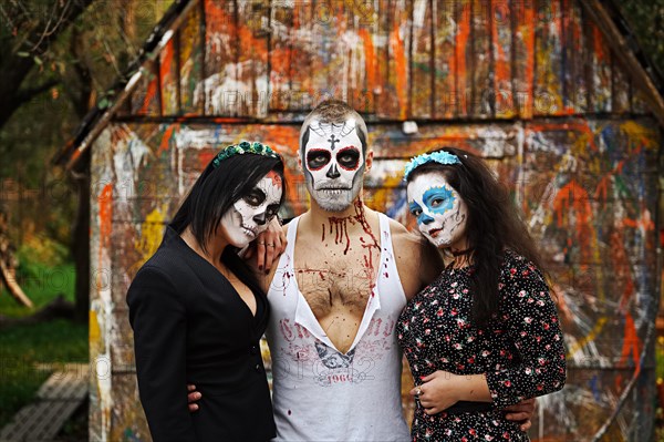 Three daemons in front of old painted barn. Face painting art