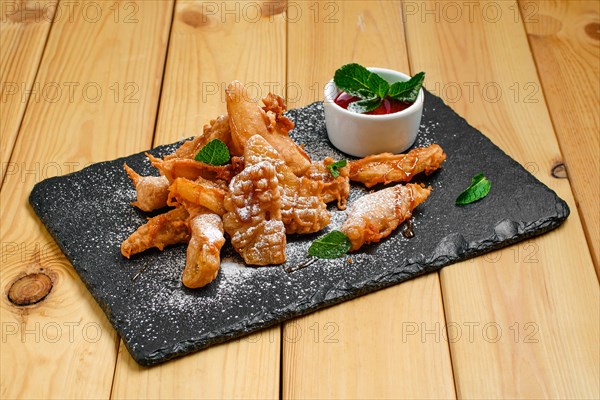 Deep fried fruits in breading served with caramel and strawberry jam