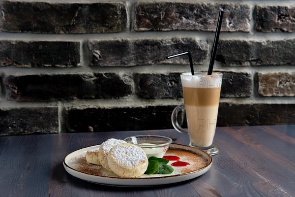 Traditional breakfast with cottage cheese pancake with sour cream