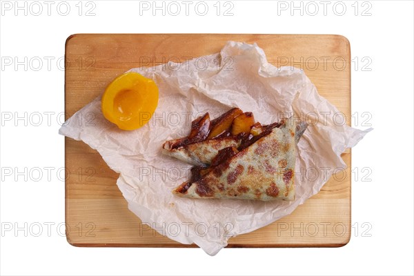 Thin pancakes stuffed with apricot and soft cheese isolated on white