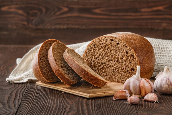 Brown garlic bread on cutting board on the table