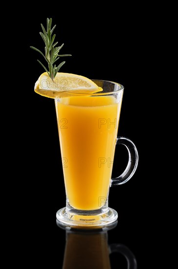 Glass of hot lemon tea with ginger and rosemary isoalted on black.