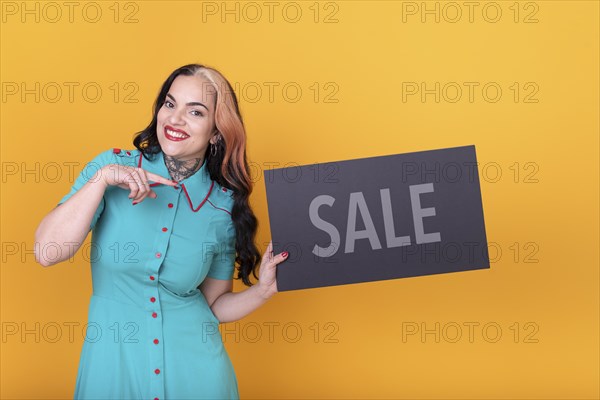 Beautiful woman pointing at a Sale sign. Commercial concept. Commerce