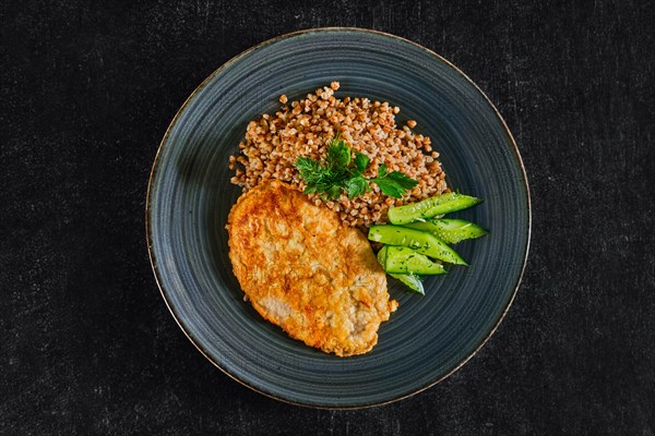 Chicken fillet fried in batter with buckwheat porridge and pickled cucumber