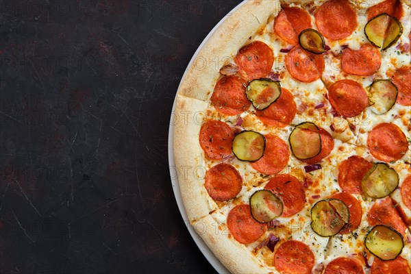 Top view of pizza with pickled cucumber and pepperoni sausage