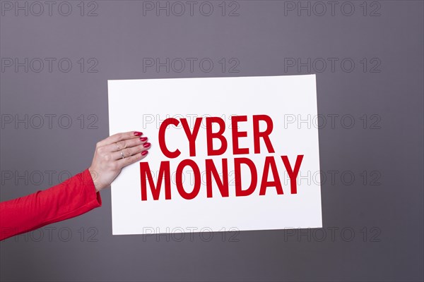 Female hand holding a cyber monday poster. Commercial concept