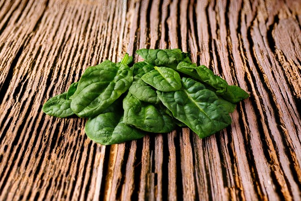 Leavews of fresh spinach on wooden background