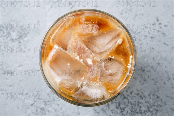 Top view of iced coffee with fat cream in rocks glass