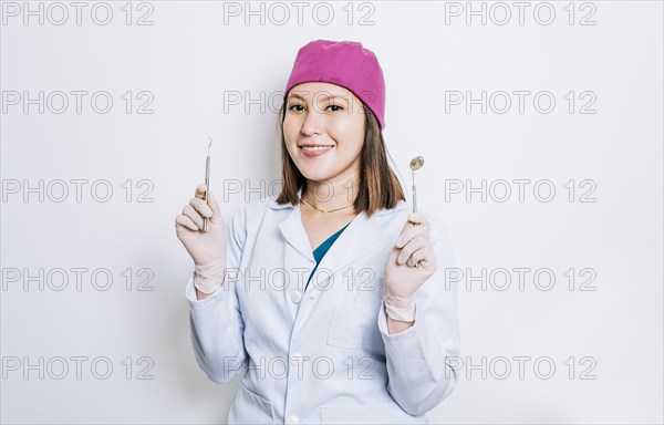 Portrait of a dentist woman holding dental tools