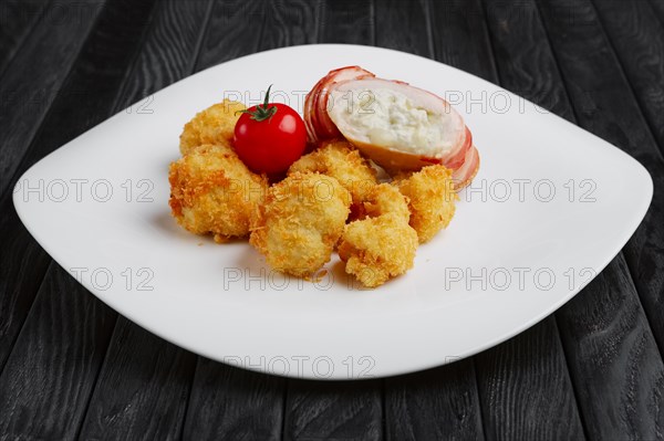 Feta cheese wrapped by bacon and fried in oil with potato in breading