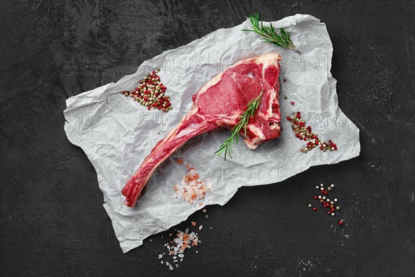 Top view of raw prime ribeye steak on wooden wrapping paper