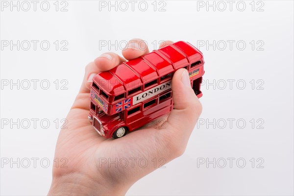 Hand holding a London double decker bus on a white background