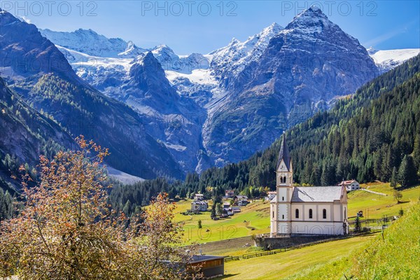 View of the village with the Church of the Visitation of the Virgin Mary and the Trafoier Ice Wall 3565m