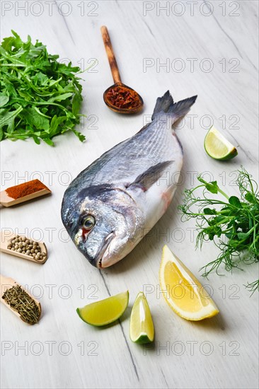 Dorada fish on the table with spice and herbs