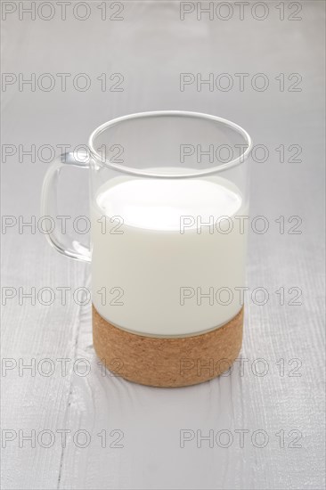 Glass of milk on white wooden kitchen table