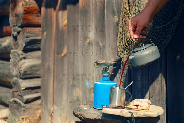 Boiling water in hiking kettle. Outdoor cooking equipment