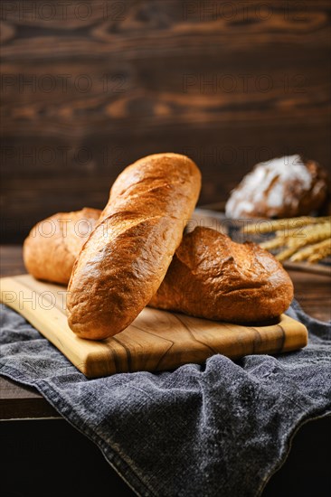 Fresh loaf of wheat bread on wooden cutting board