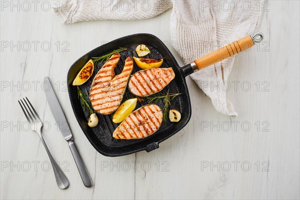 Overhead view of grilled trout steaks on pan