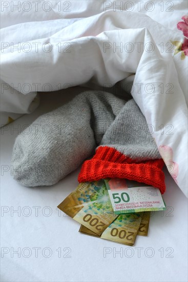 Banknotes in stocking under duvet