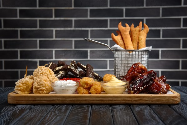 Large plate with a wide selection of snacks for beer in bar. Various salty and spicy appetizers